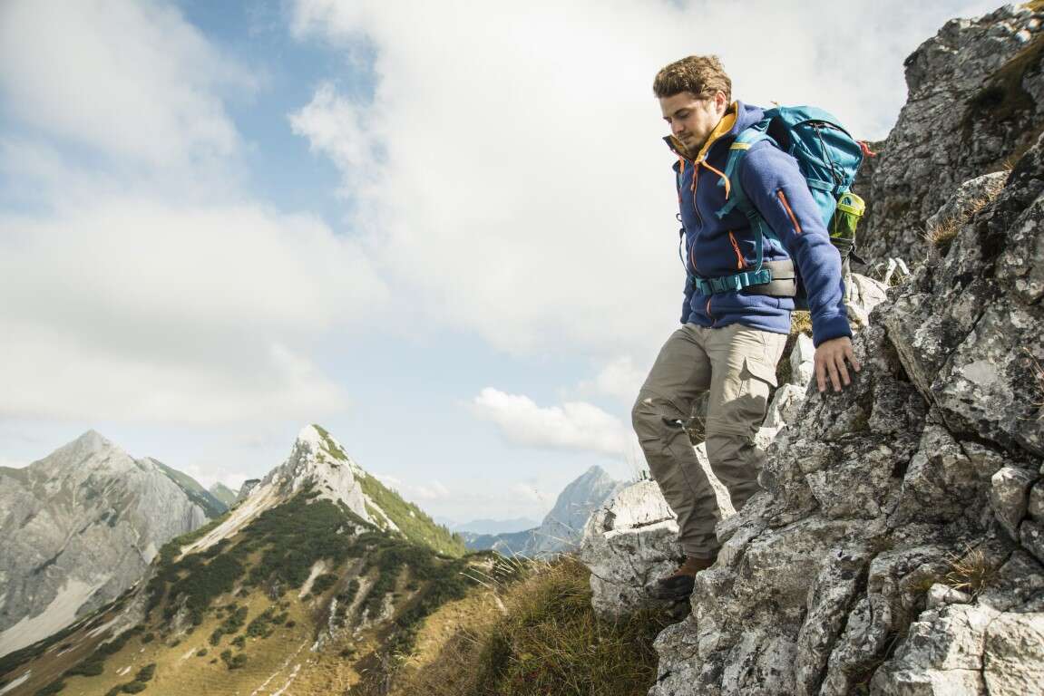Austria, Tyrol, Tannheimer Tal, young man hiking on rock