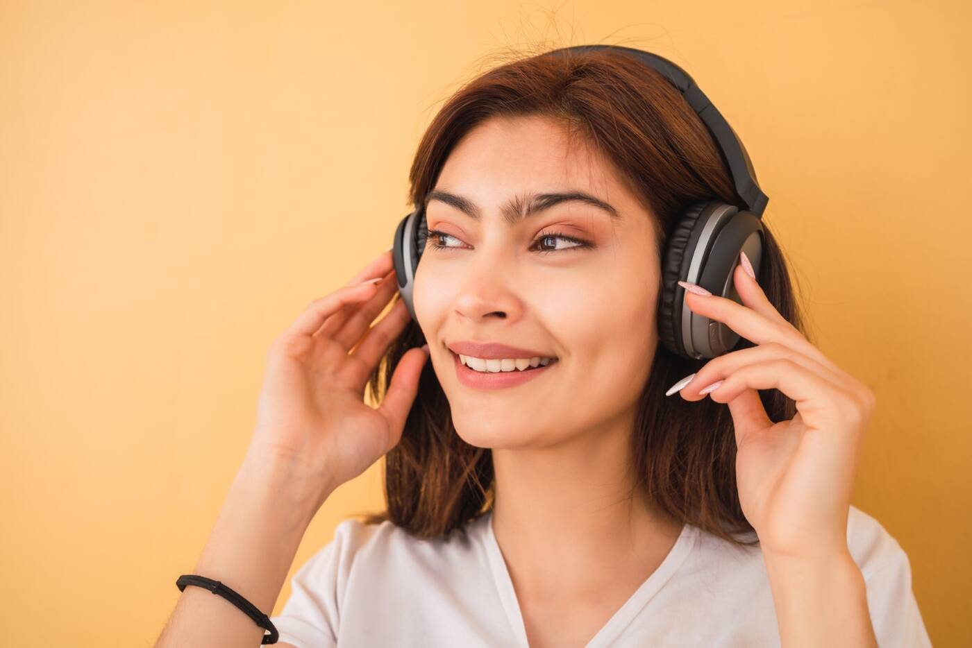 Młoda kobieta słucha muzyki na słuchawkach