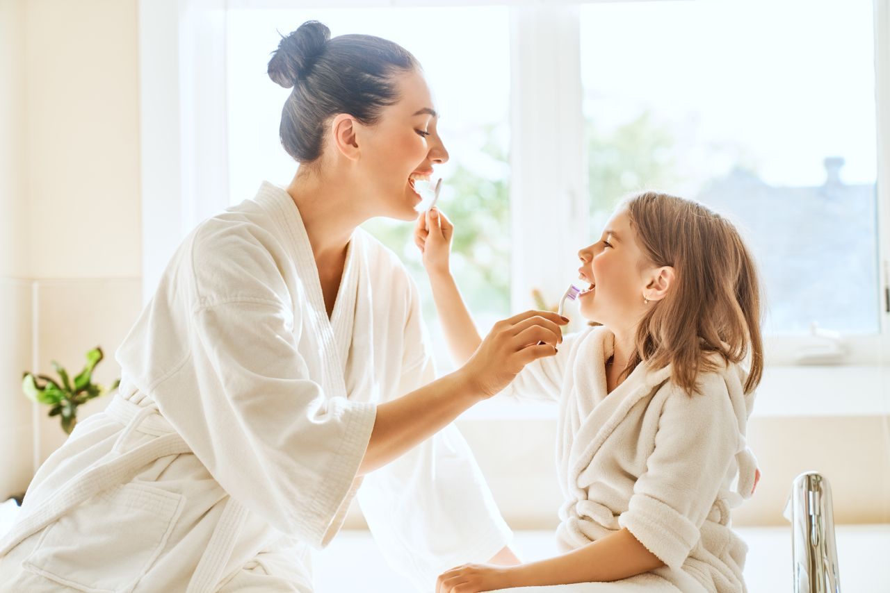 kobieta z dzieckiem myje zęby