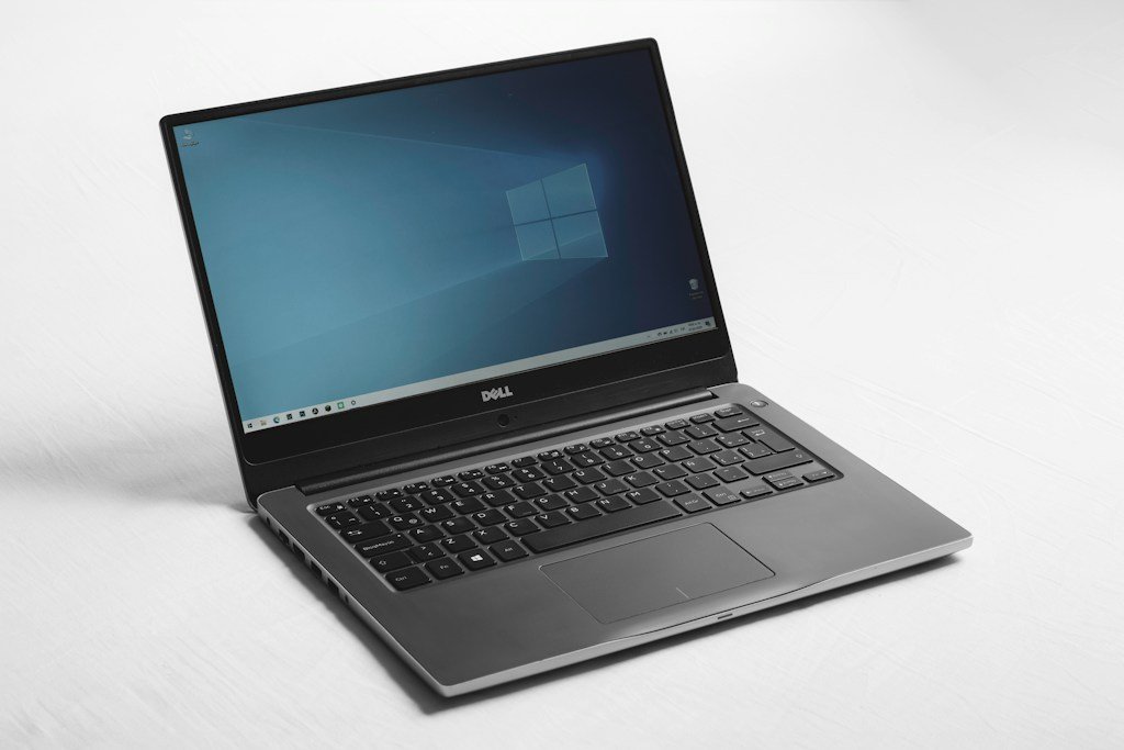 Dwa laptopy biznesowe obok siebie na biurku – klasyczny ThinkPad i smukły Dell Latitude